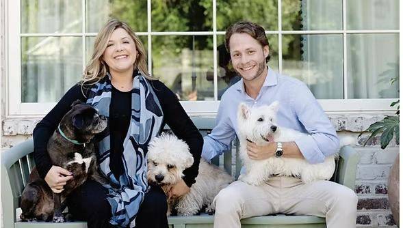 Maggie Brydon and Coleman Russell sitting on a porch bench with their dogs.